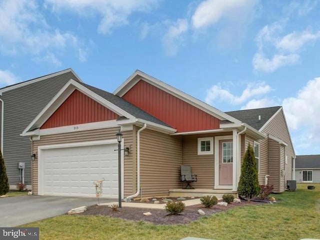 view of front of property featuring a garage, central air condition unit, and a front lawn