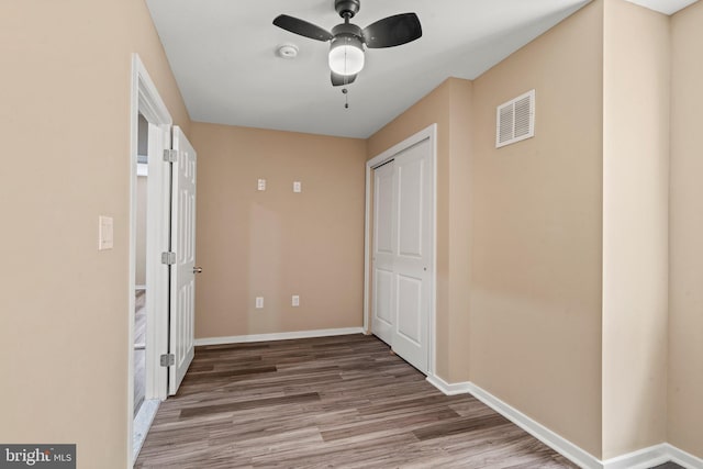 corridor with hardwood / wood-style flooring