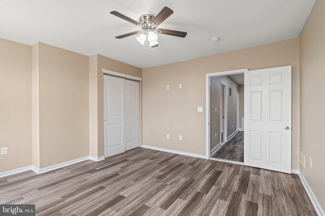 unfurnished bedroom with ceiling fan, a closet, and dark hardwood / wood-style floors