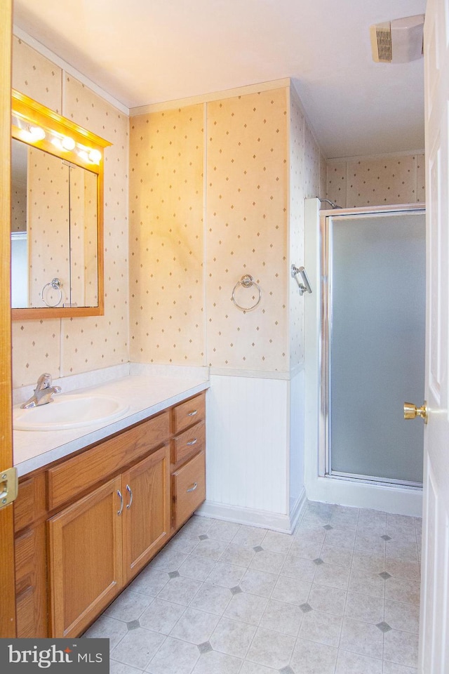 bathroom with tile patterned floors, a shower with door, and vanity