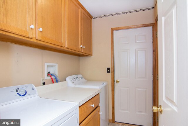 clothes washing area featuring washer and dryer and cabinets