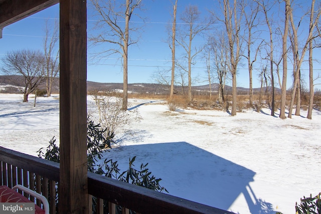 yard covered in snow featuring a mountain view