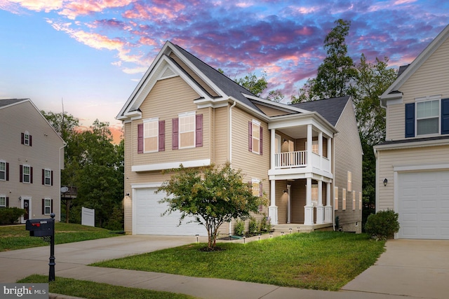 view of front facade featuring a garage, a yard, and a balcony