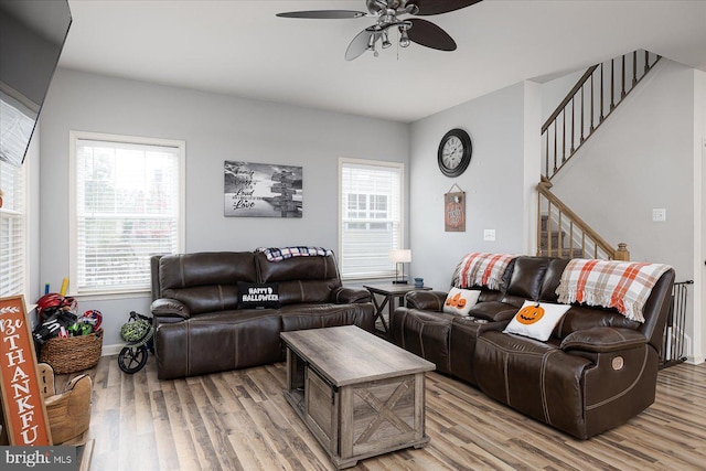 living room with light hardwood / wood-style flooring and ceiling fan