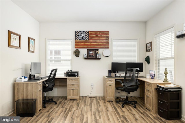 home office with light hardwood / wood-style flooring and plenty of natural light