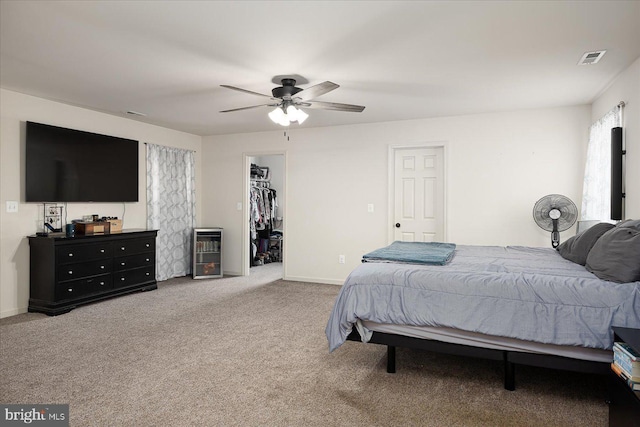 bedroom with carpet, a walk in closet, wine cooler, ceiling fan, and a closet