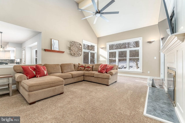 living room featuring a wealth of natural light, high vaulted ceiling, ceiling fan, and carpet