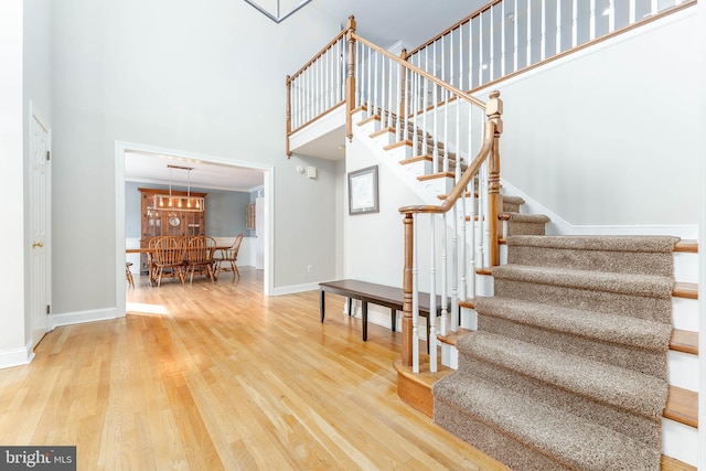 stairs featuring hardwood / wood-style flooring and a high ceiling