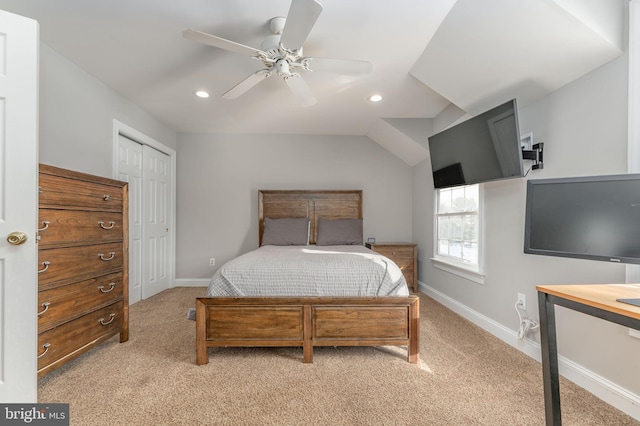 bedroom featuring vaulted ceiling, light colored carpet, ceiling fan, and a closet