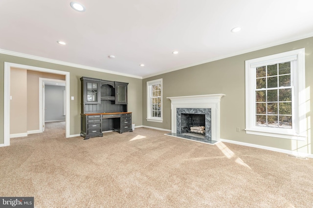 unfurnished living room featuring a fireplace, ornamental molding, and carpet flooring