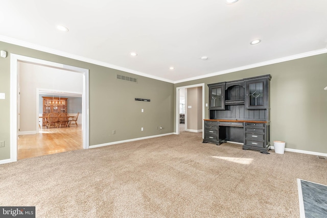 unfurnished living room featuring ornamental molding and carpet flooring