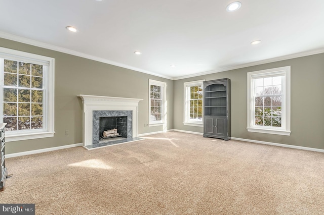 unfurnished living room with crown molding, light colored carpet, and a premium fireplace