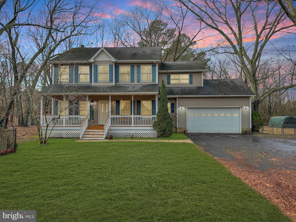 view of front facade featuring a yard, a porch, and a garage