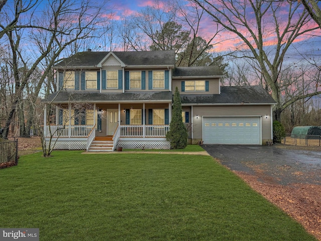 view of front facade featuring a yard, a porch, and a garage