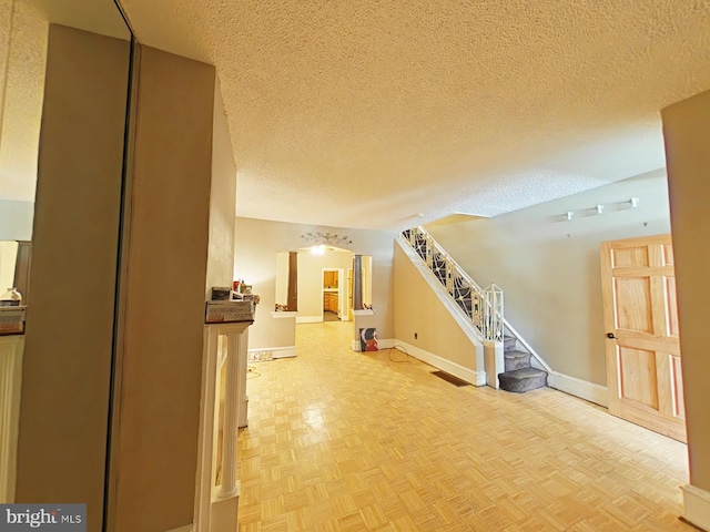 interior space featuring light parquet flooring and a textured ceiling