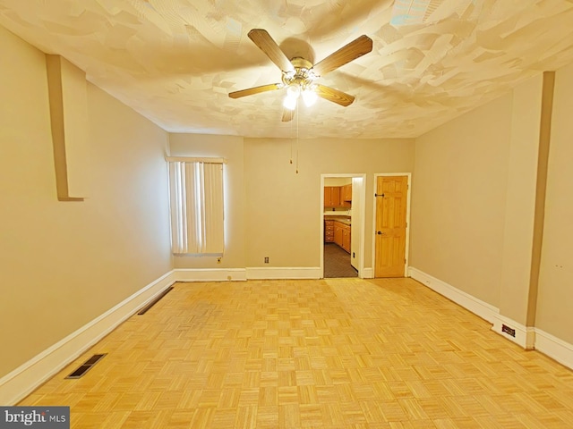 unfurnished room featuring ceiling fan and light parquet flooring