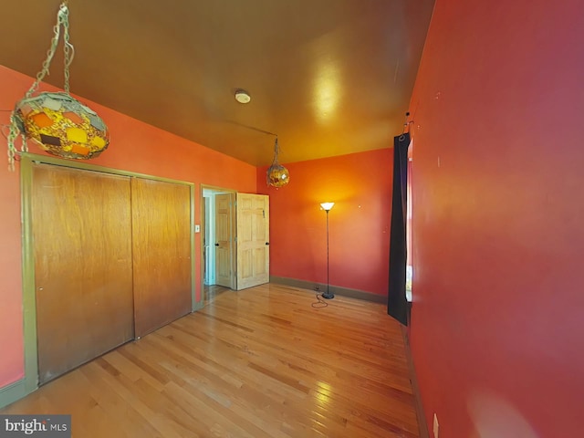 hall with vaulted ceiling and hardwood / wood-style floors