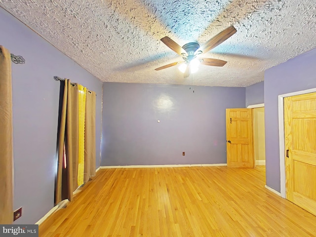 unfurnished bedroom featuring ceiling fan, light hardwood / wood-style floors, and a textured ceiling