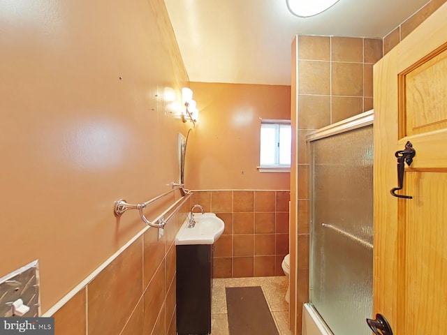 bathroom with vanity, toilet, and tile walls