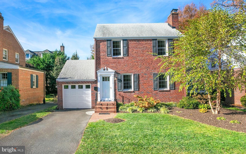 view of front of property with a front lawn and a garage