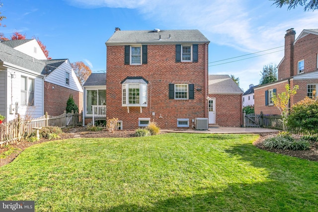 back of property with a patio area, central air condition unit, and a yard