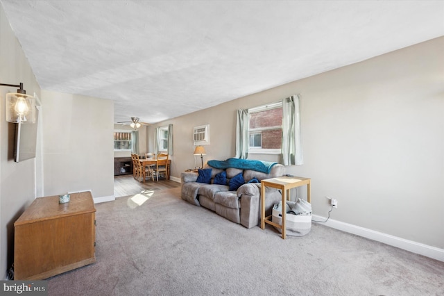 carpeted living room featuring ceiling fan and an AC wall unit