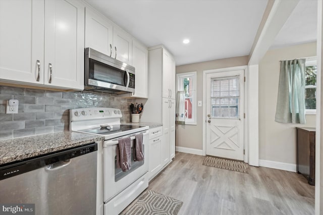 kitchen with light stone counters, white cabinets, appliances with stainless steel finishes, and tasteful backsplash