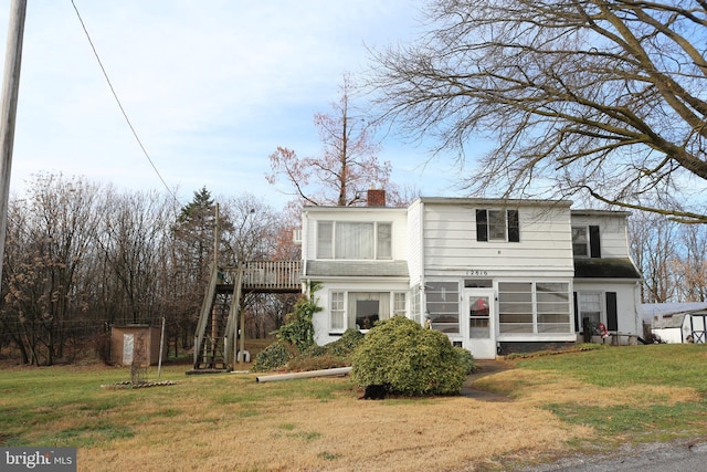 rear view of house featuring a lawn