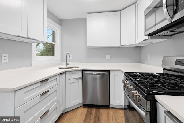 kitchen featuring white cabinets, appliances with stainless steel finishes, dark hardwood / wood-style floors, and sink