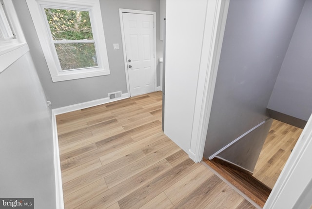 hallway with light hardwood / wood-style floors