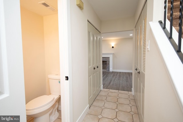 interior space featuring hardwood / wood-style flooring and toilet