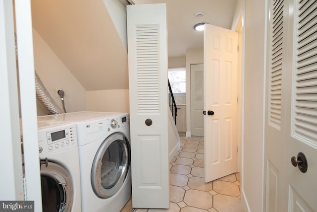 laundry room with washing machine and dryer and light tile patterned floors