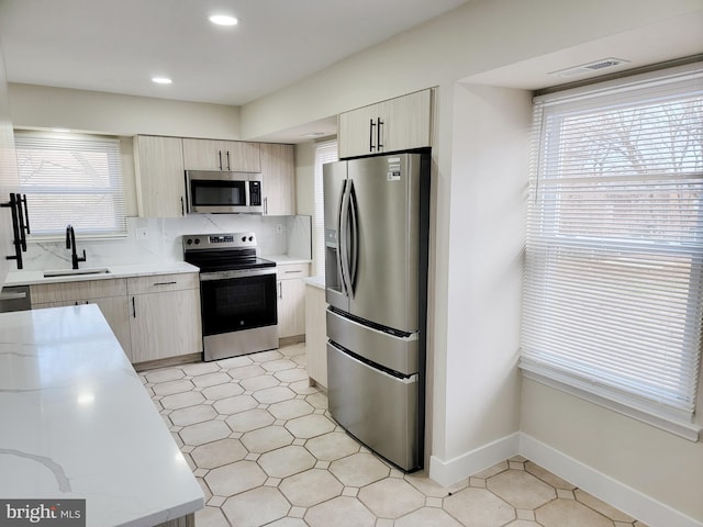 kitchen featuring backsplash, sink, and stainless steel appliances