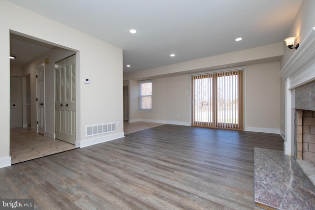 unfurnished living room featuring light wood-type flooring and a premium fireplace