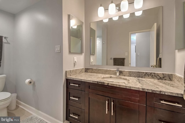 bathroom with tile patterned flooring, vanity, and toilet