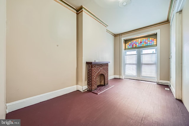 unfurnished living room featuring hardwood / wood-style floors, a fireplace, and ornamental molding