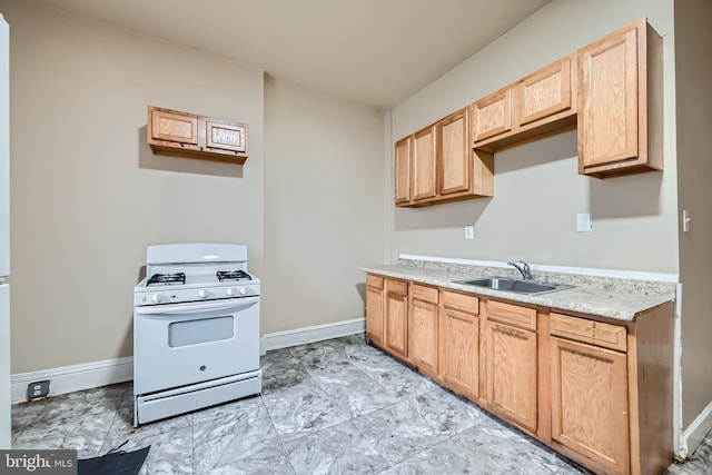 kitchen featuring white gas range and sink