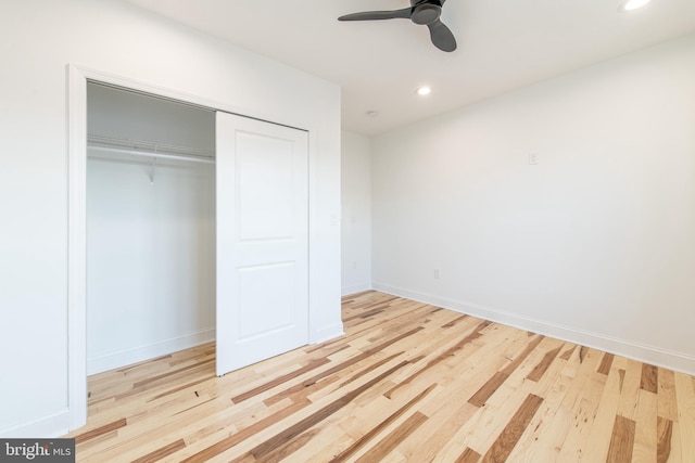 unfurnished bedroom featuring ceiling fan, light wood-type flooring, and a closet