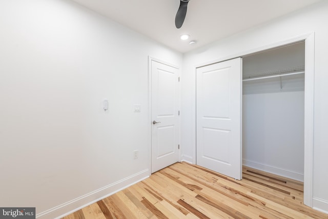 unfurnished bedroom featuring hardwood / wood-style flooring, a closet, and ceiling fan