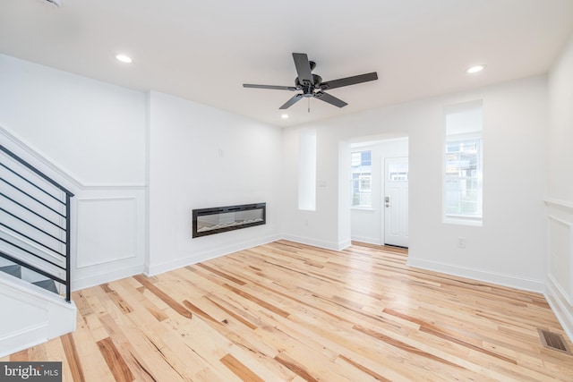 unfurnished living room with ceiling fan and light wood-type flooring