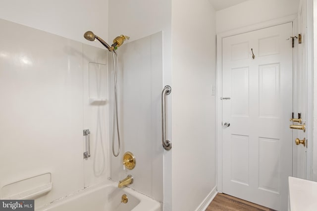 bathroom with wood-type flooring and  shower combination