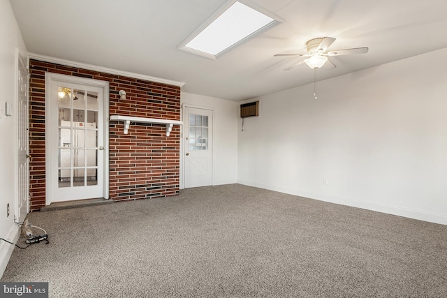 carpeted spare room featuring ceiling fan and brick wall