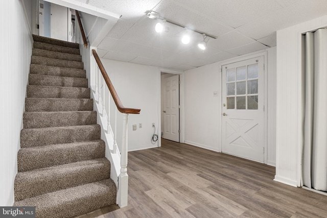 basement featuring hardwood / wood-style floors and rail lighting