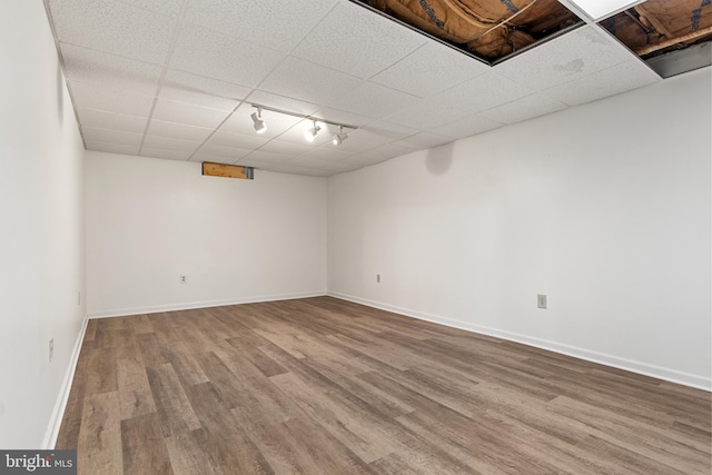 basement with hardwood / wood-style floors and a drop ceiling