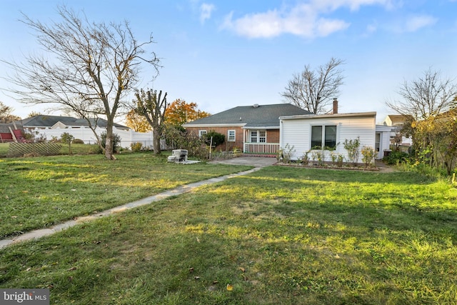 rear view of property featuring a lawn