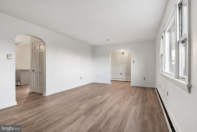 empty room with light hardwood / wood-style flooring and a baseboard radiator