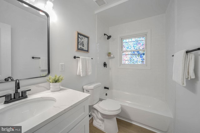 full bathroom featuring hardwood / wood-style flooring, vanity, toilet, and tiled shower / bath