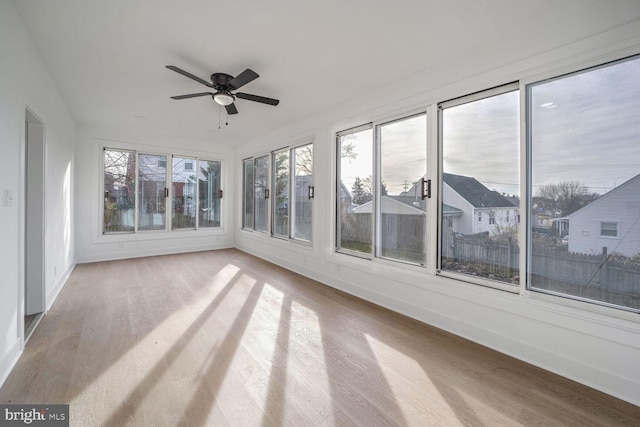 unfurnished sunroom featuring ceiling fan