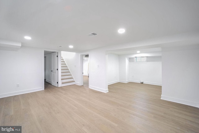 basement with light hardwood / wood-style floors