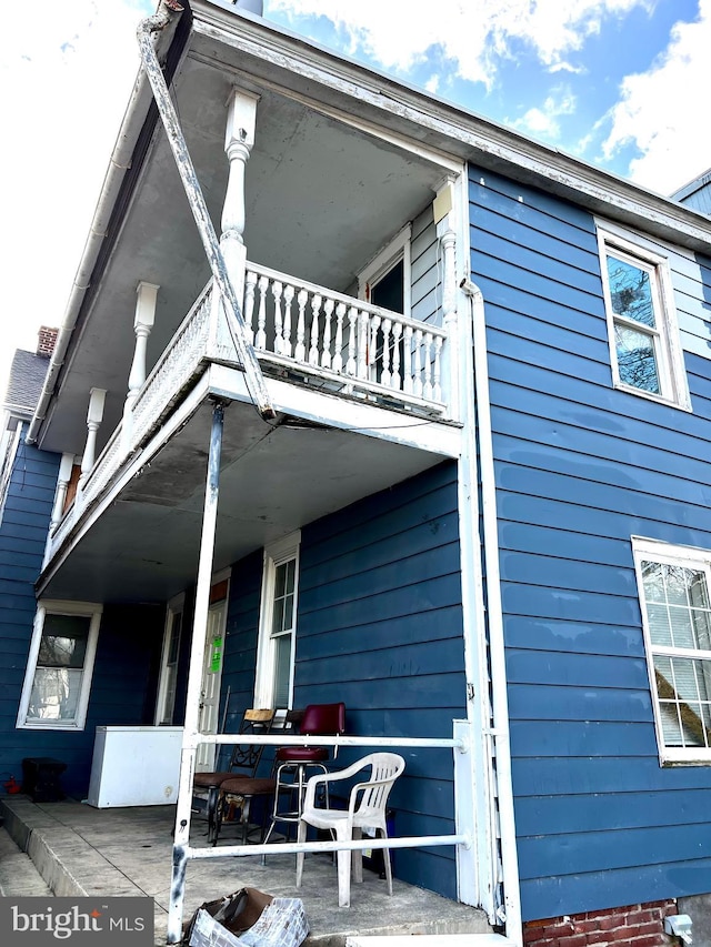 back of house featuring a balcony and a patio area